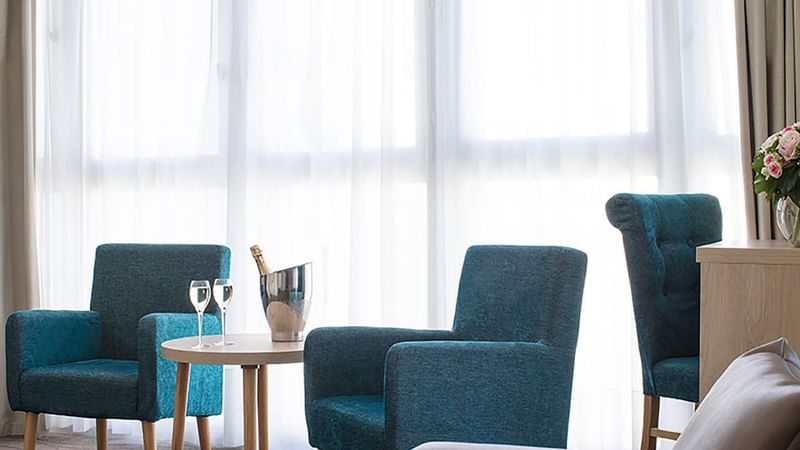 Two comfy chairs and a coffee table with a champagne bottle in Suite at Splendid Hotel & Spa Nice