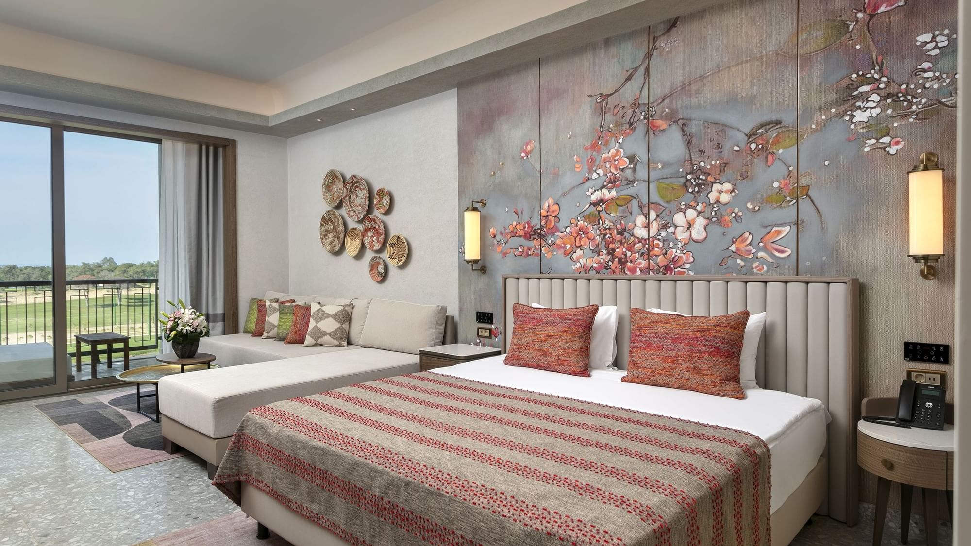 Seating area by the bed in Superior Room Golf View with floral wall art at Cullinan Belek