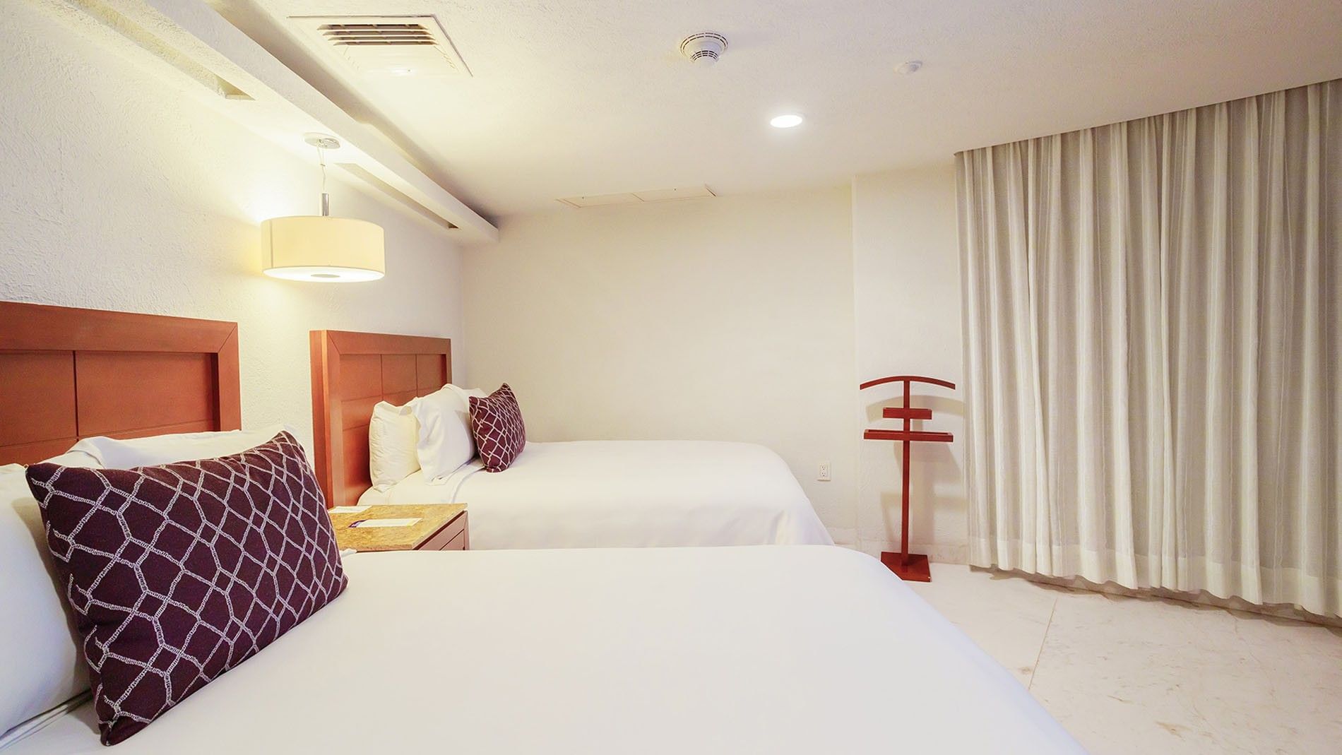 King Master Suite featuring two queen beds with white linens and warm wooden headboards at Camino Real Veracruz