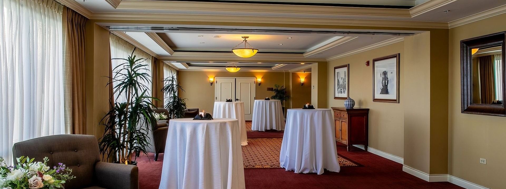 Cocktail tables with white cloths by an armchair under dome in Millennium at Warwick Denver