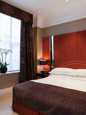 Bed between the side tables near the window in Classic Townhouse Room at The Capital Hotel, Apartments and Townhouse