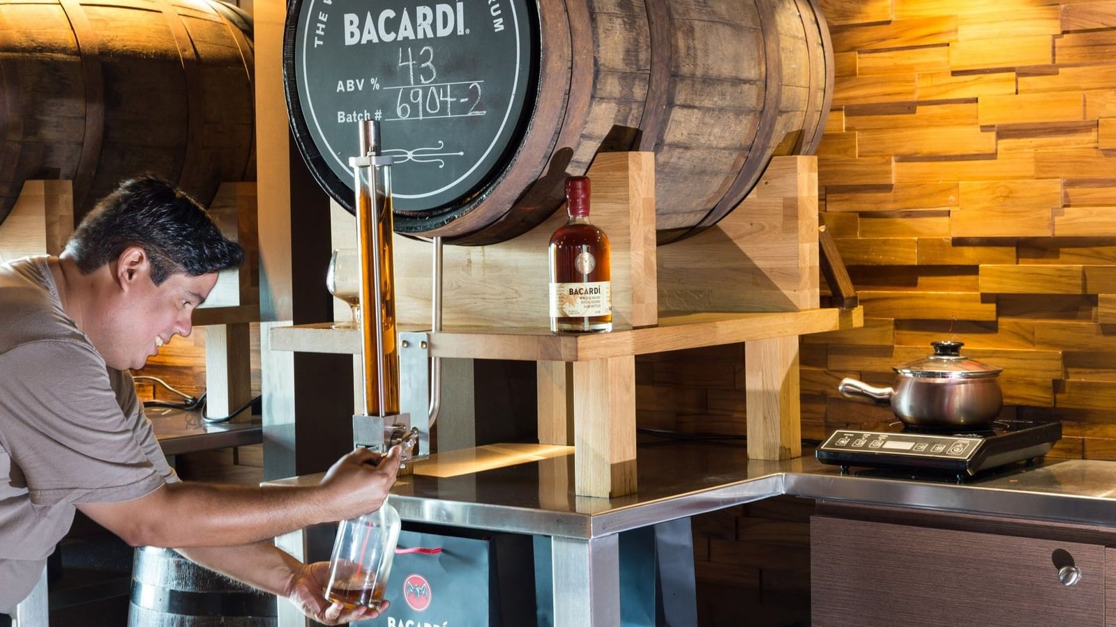 Man pouring Bacardi rum from barrel into glass at Casa Bacardi.