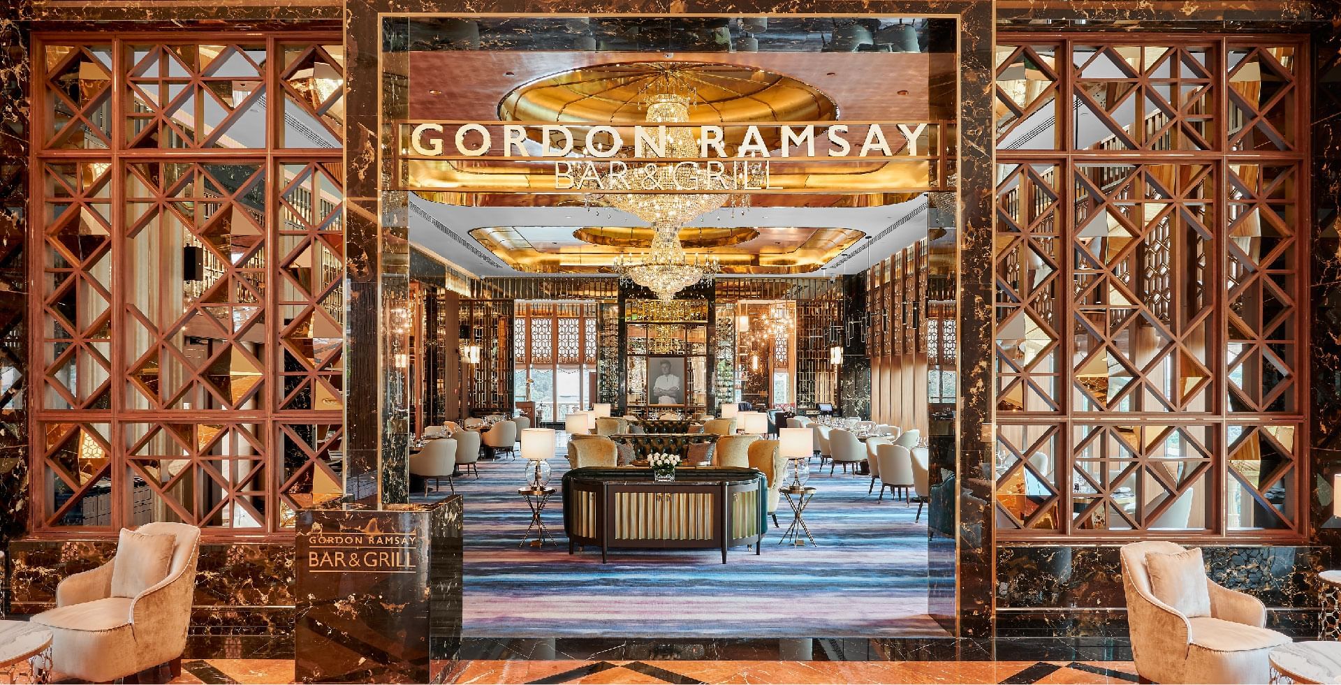 Grand entrance to Gordon Ramsay Bar & Grill, at Sunway resort, showcasing opulent decor and chandeliers