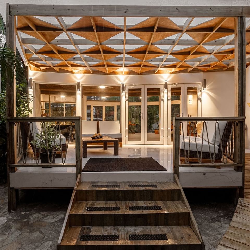 Exterior view of a patio lounge area with warm lighting and wooden accents at Paradise Beach Hotel