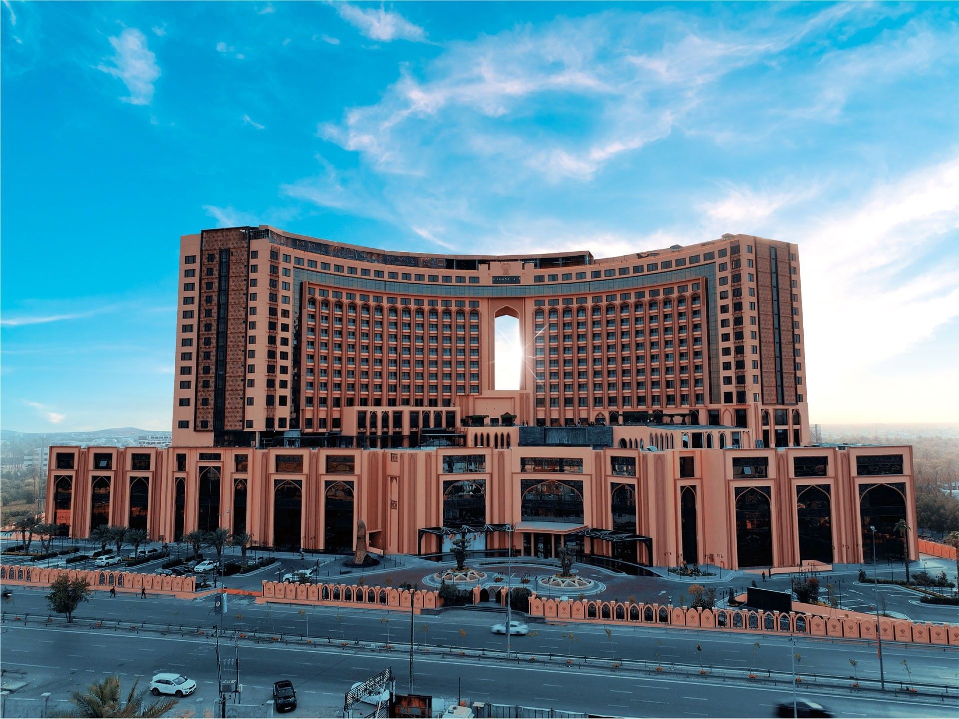 Large modern hotel building with many windows and a unique design in an urban setting.