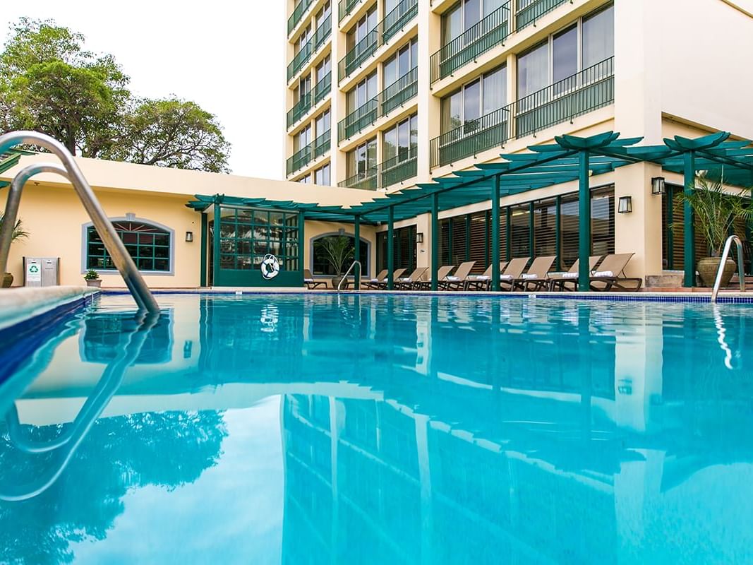 Sunbeds by the outdoor pool at Courtleigh Hotel & Suites
