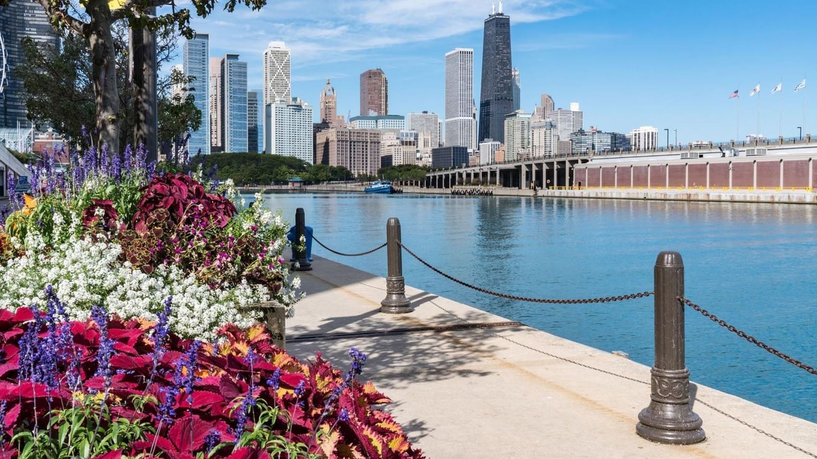 Riverside path with colorful flowers and posts by a lake near Warwick Allerton Chicago
