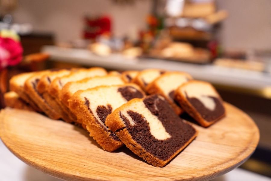 Gros plan sur des tranches de gâteau marbré disposées sur une planche en bois chez Warwick Paris Champs-Élysées