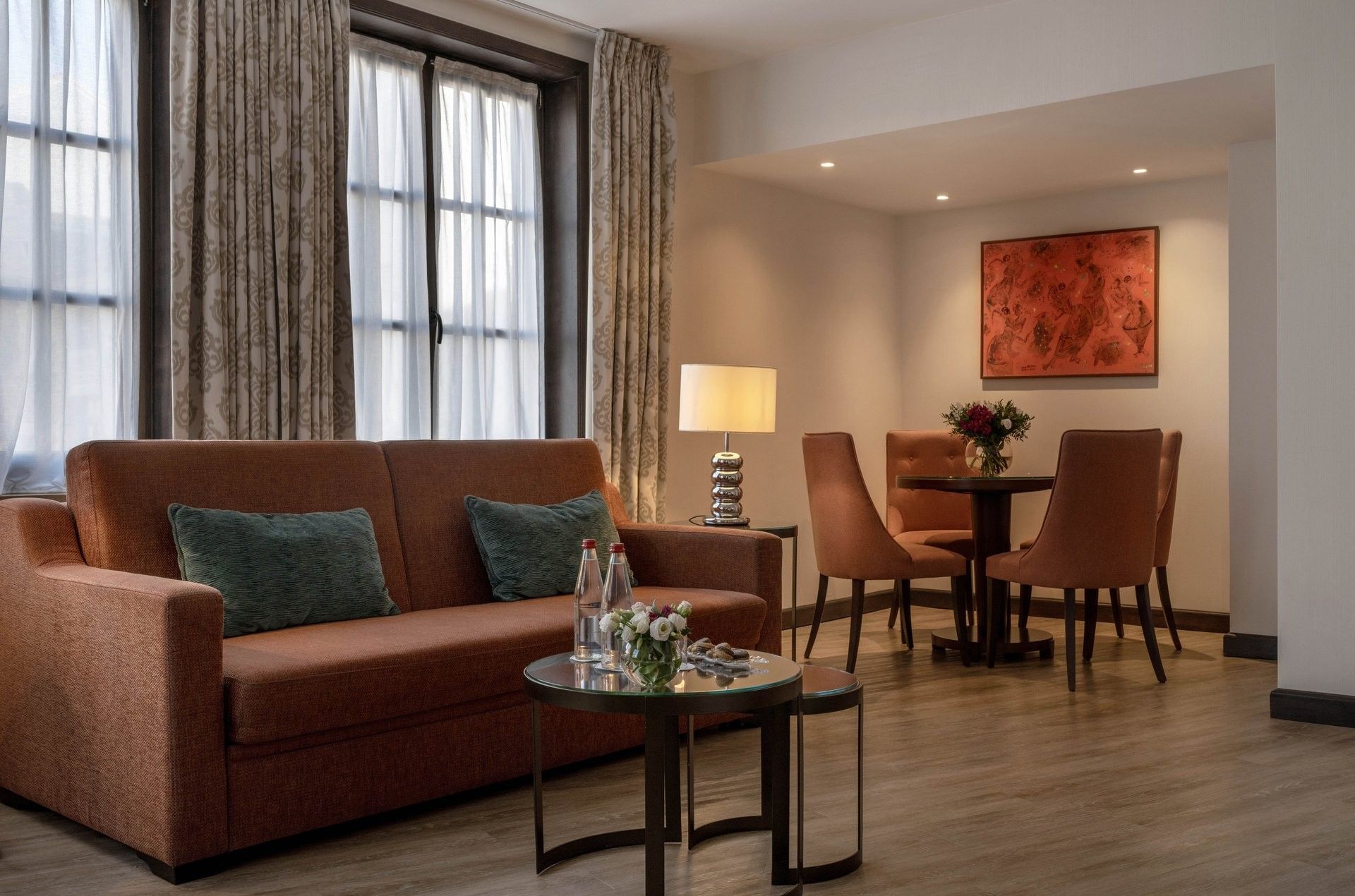 Junior Suite Privilege View living area featuring a sofa with a dining table near window at Warwick Grand Place Brussels