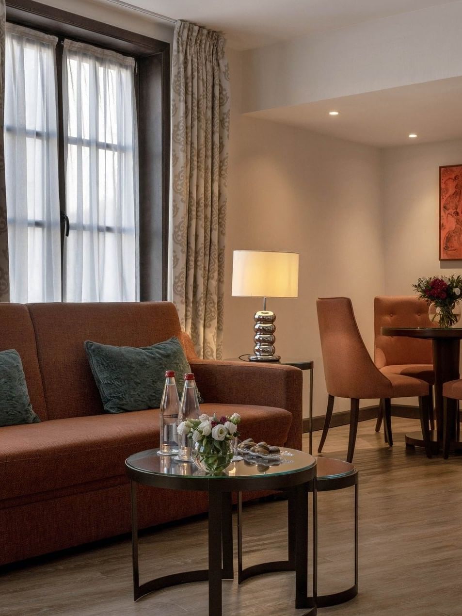 Junior Suite Privilege View living area featuring a sofa with a dining table near window at Warwick Grand Place Brussels