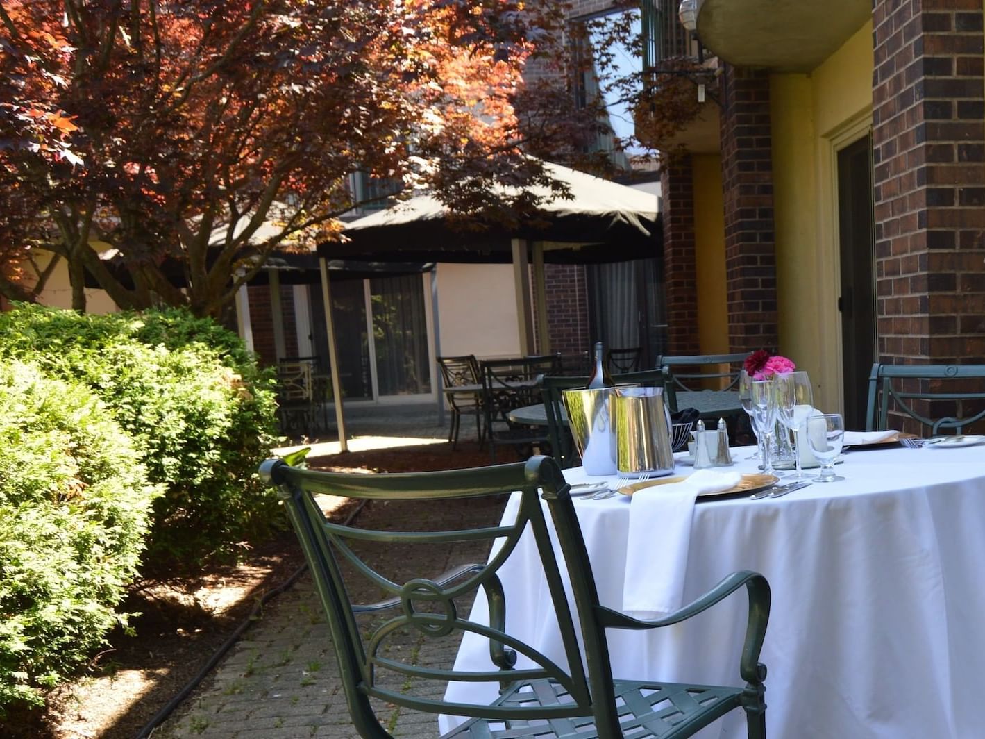view of dining area with bushes & trees at The Inn of Waterloo
