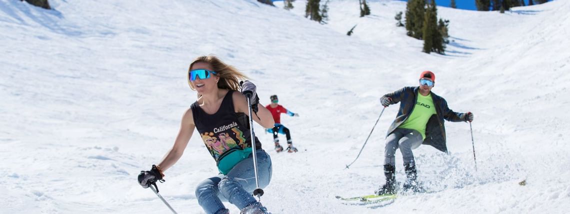 Three skiers at Palisades Tahoe spring skiing in tshirts