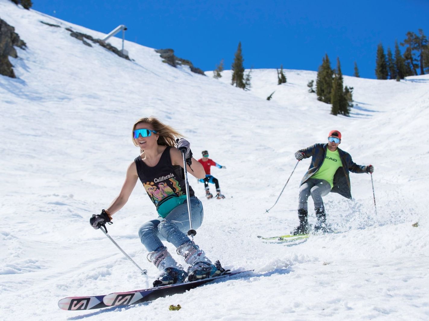 Three skiers at Palisades Tahoe spring skiing in tshirts