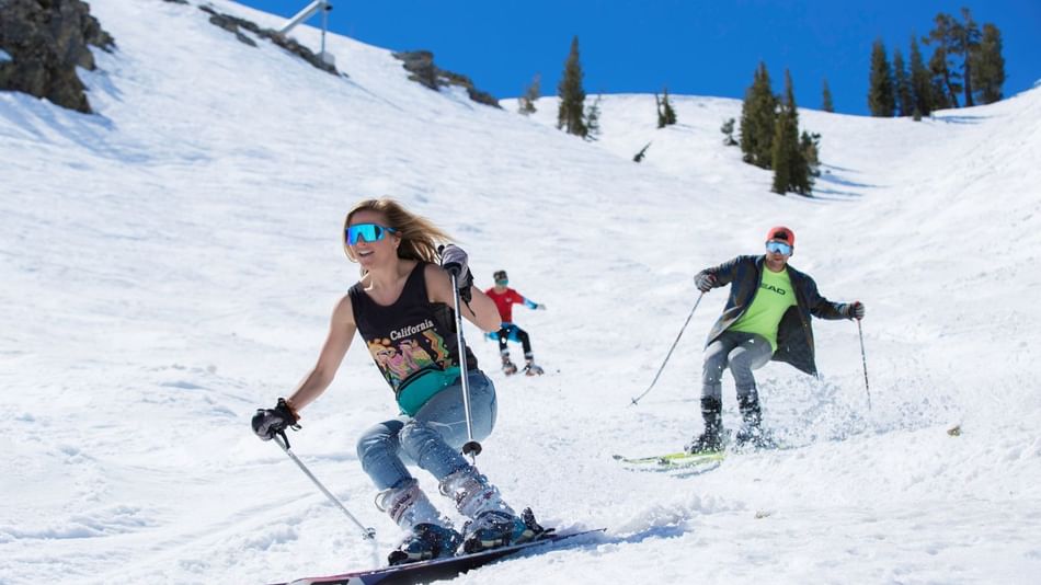 Three skiers at Palisades Tahoe spring skiing in tshirts