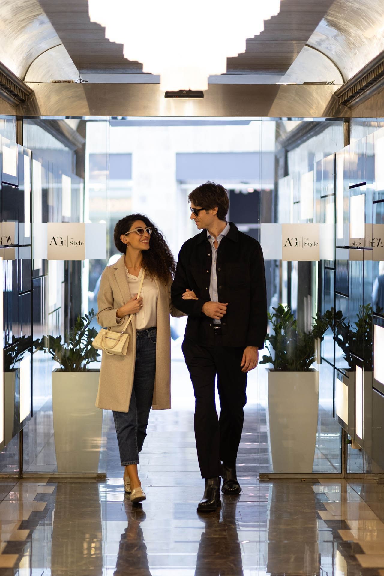 Couple walking into the Hotel from the entrance while looking at each other in The Style
