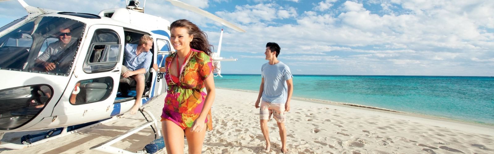 People getting off from helicopter on beach at Pullman Port Douglas Sea Temple Resort & Spa