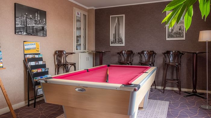 Billiard table with high chairs at The Originals Hotels