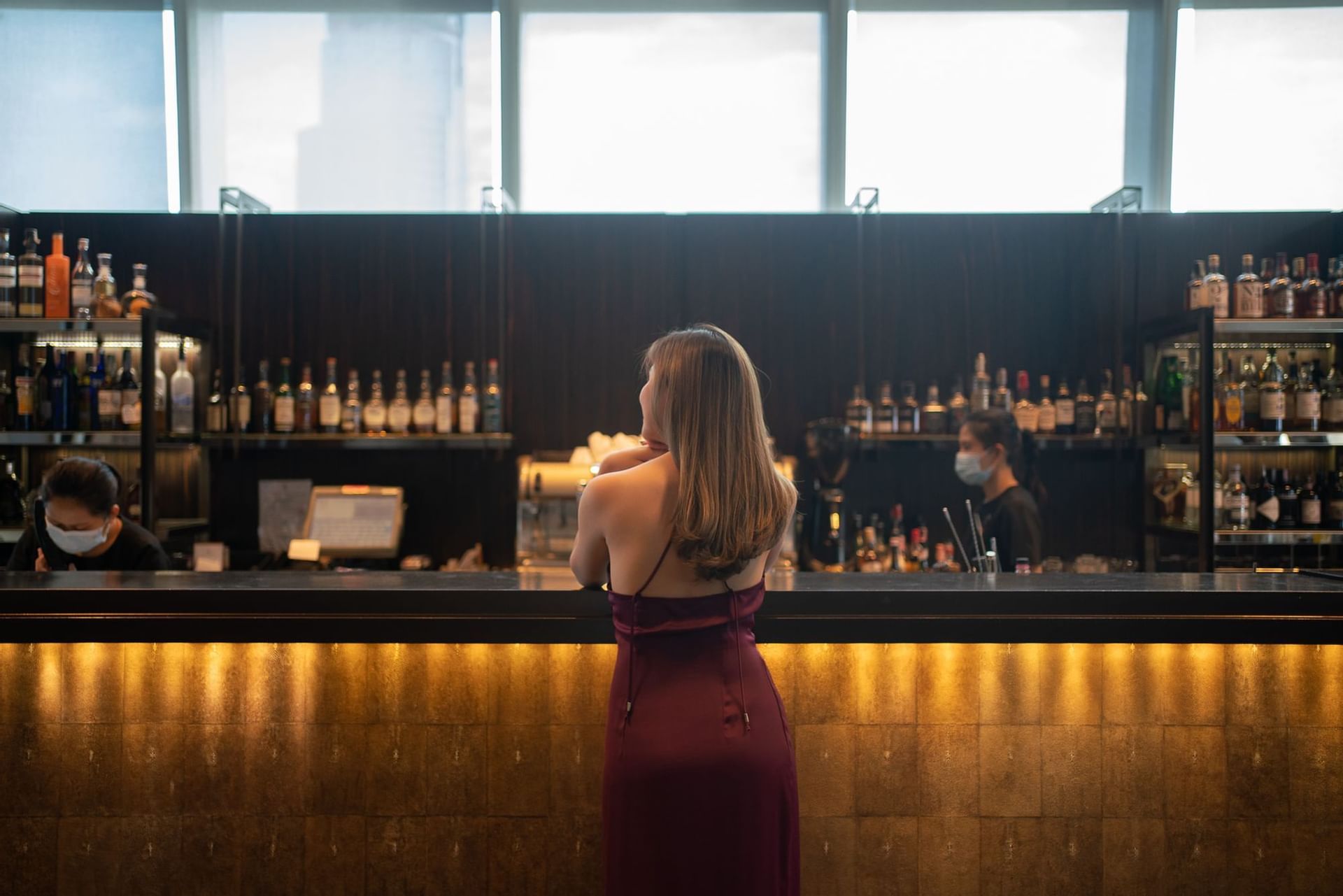 A girl looking at the bar area at The Okura Prestige Bangkok