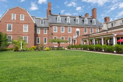 Exterior view of The Exeter Inn with a large grassy lawn and a stone path