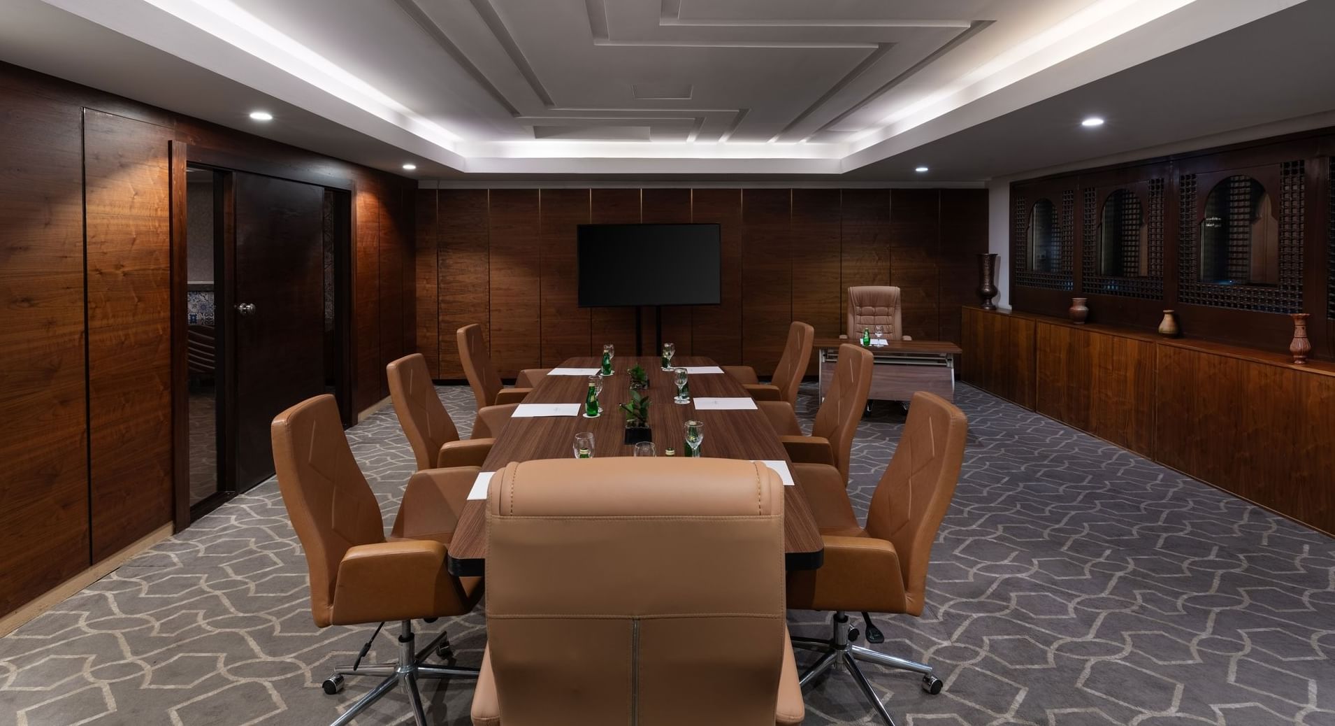 Boardroom set-up with notepads, green bottles, and carpeted floors in a meeting room at Warwick Hotel Jeddah