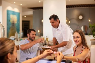 Waiter serving drinks to guests at Villa Premiere Boutique Hotel & Romantic Getaway