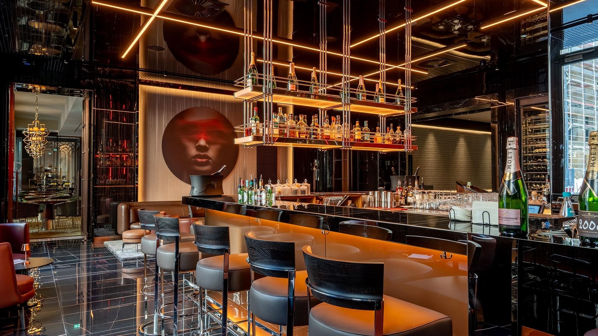 Moderne Bar mit geschwungener Theke, Barhockern und goldener Beleuchtung in The Main Bar im Titanic Gendarmenmarkt Berlin