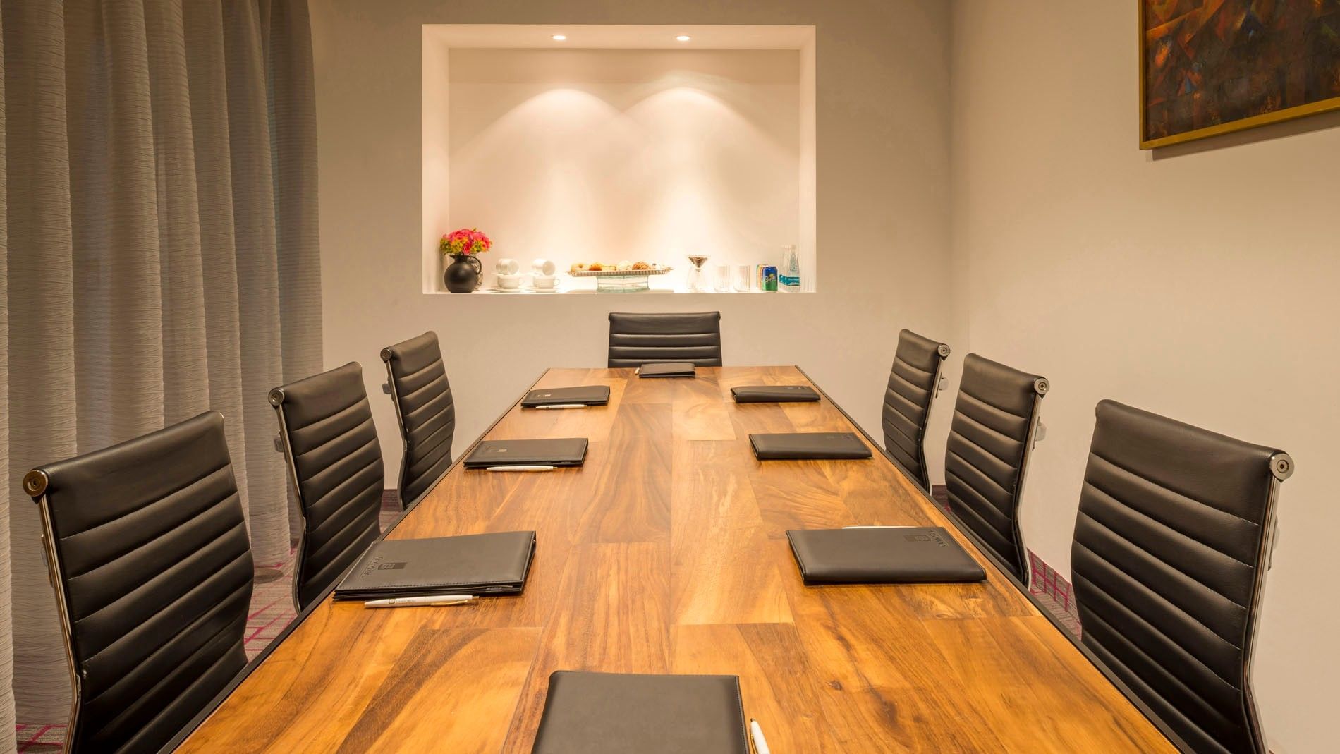 Sleek boardroom featuring a long wooden table and black leather office chairs at Camino Real Puebla Angelopolis
