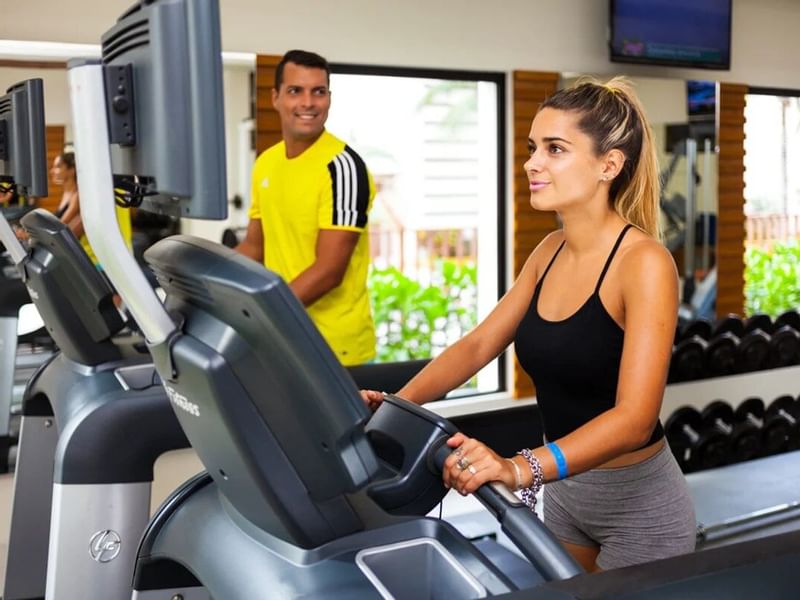 Two people in fitness center at The Reef Coco Beach hotel