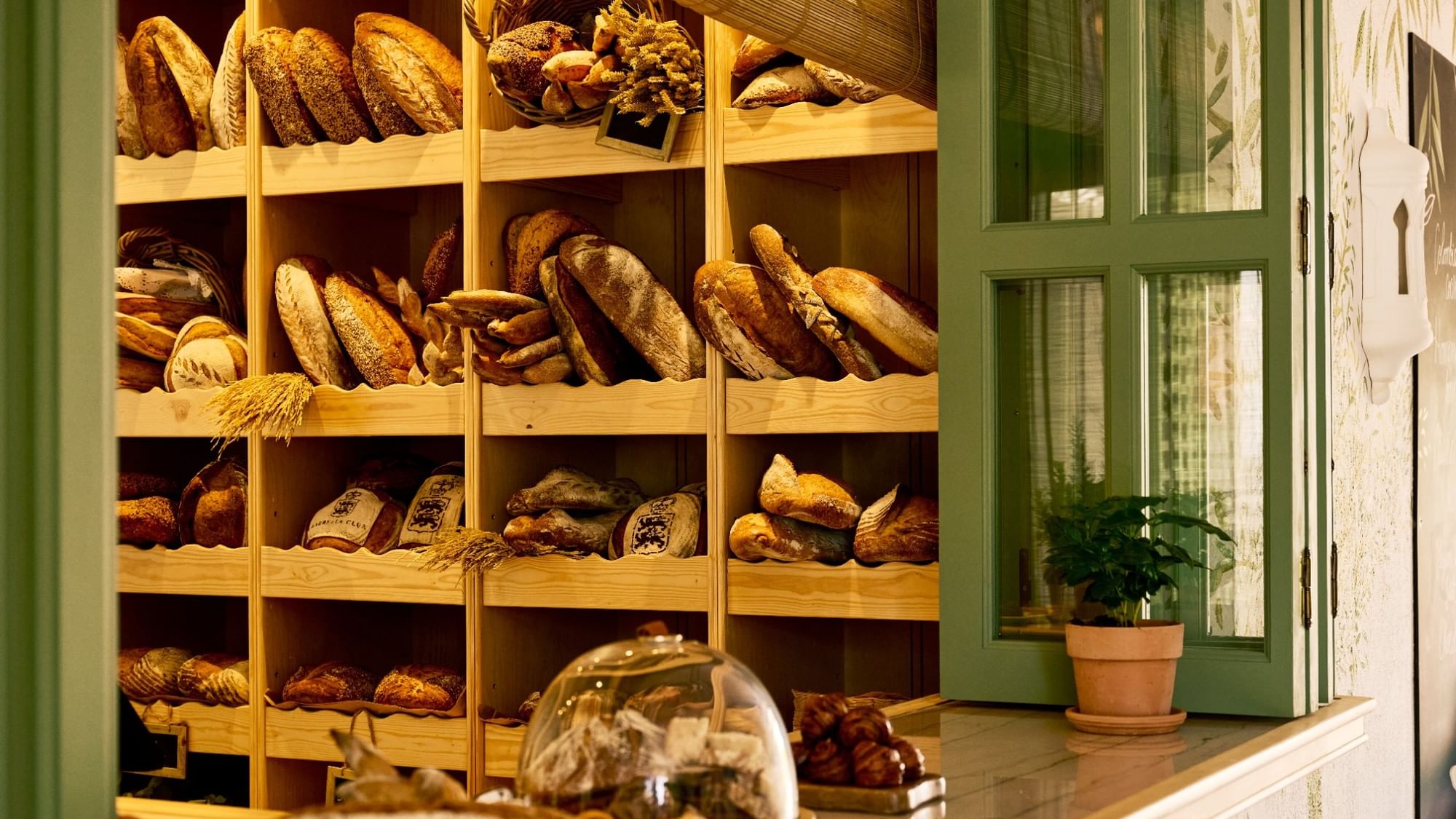 Wooden shelves displaying artisan breads and pastries at El Obrador restaurant at Marbella Club in Marbella