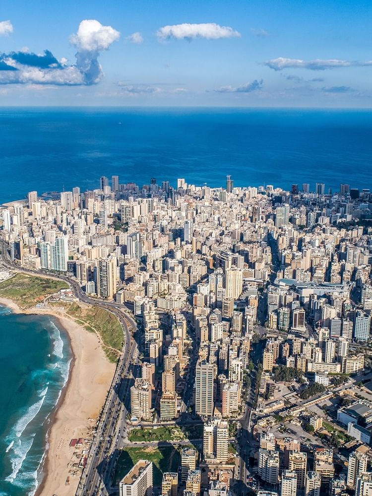 Aerial view of Beirut, featuring high-rise buildings and a coastal road near Warwick Hotels & Resort