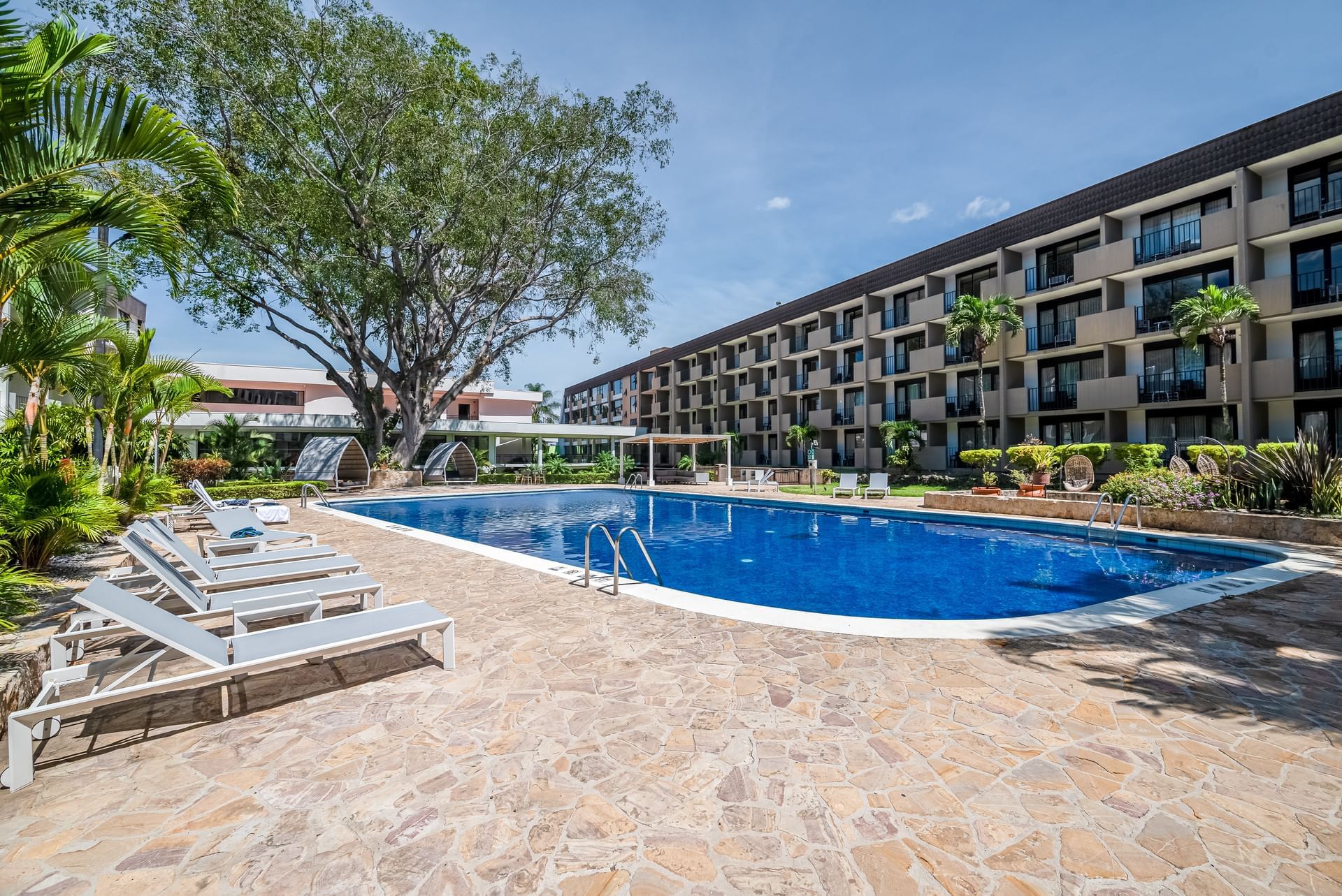 Área de piscina al aire libre con cómodas sillas de piscina en Hotel Irazu