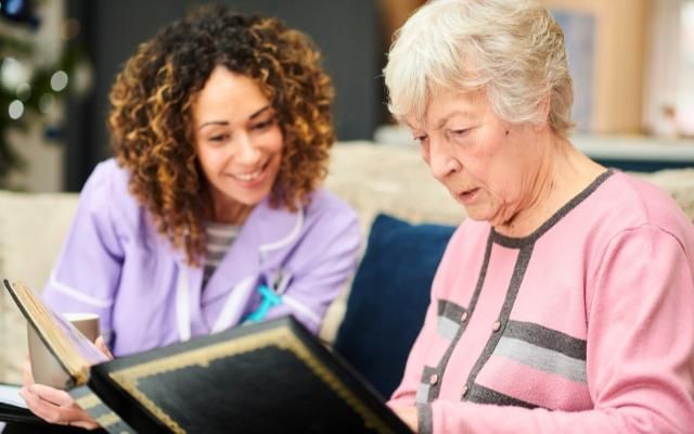 nurse reading with lady who is a dementia patient