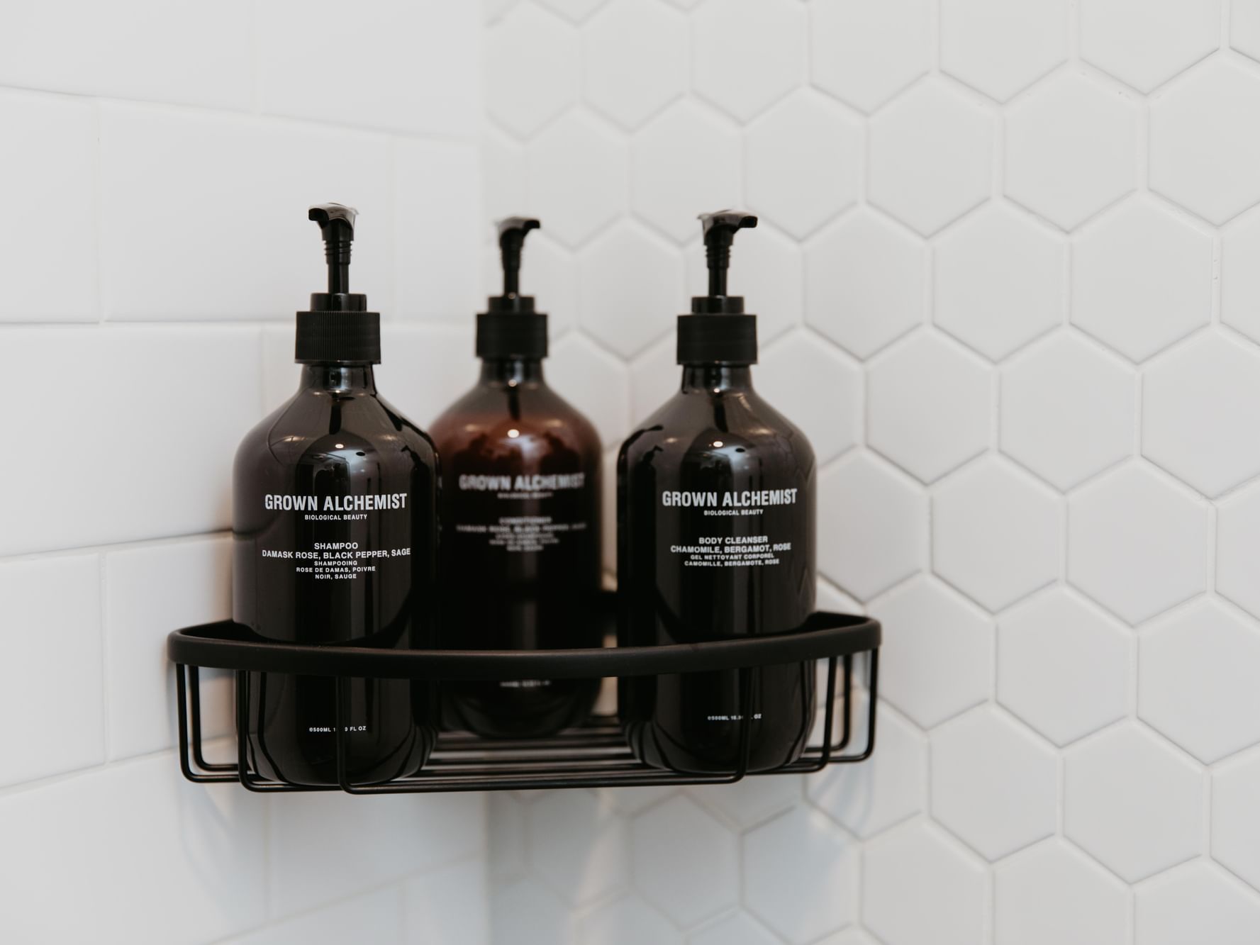 Grown Alchemist amenities on a shelf against white tiles in Deluxe Room bathroom at Gansevoort Meatpacking NYC