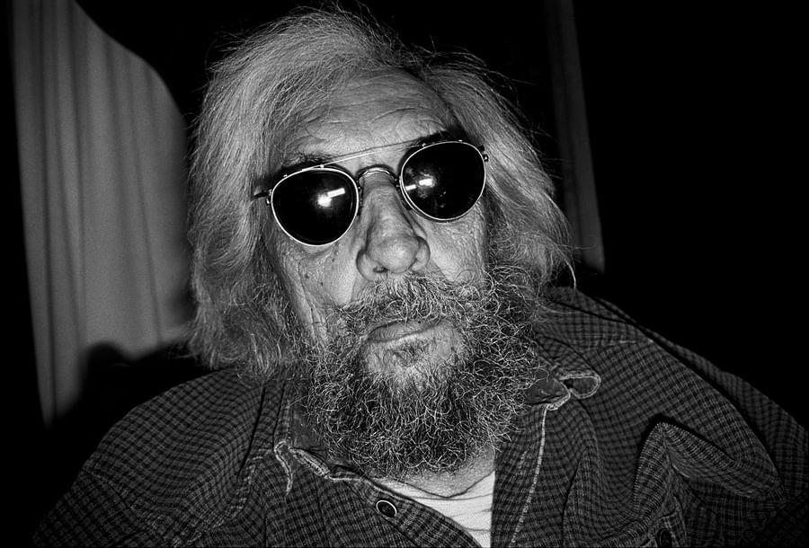 Black and white portrait of a bearded man wearing round sunglasses and a checkered shirt at Warwick Le Crystal Montreal