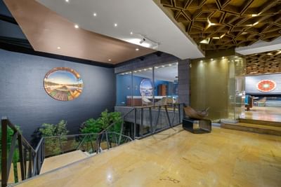 Escaleras y barandillas de cristal que conducen a una sala de estar con un techo de diseño.