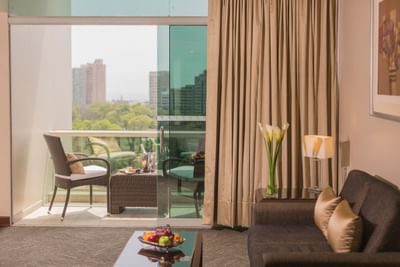 Junior Suite with lounge and balcony seating area offering a view of the golf course at Hotel Los Delfines & Casino