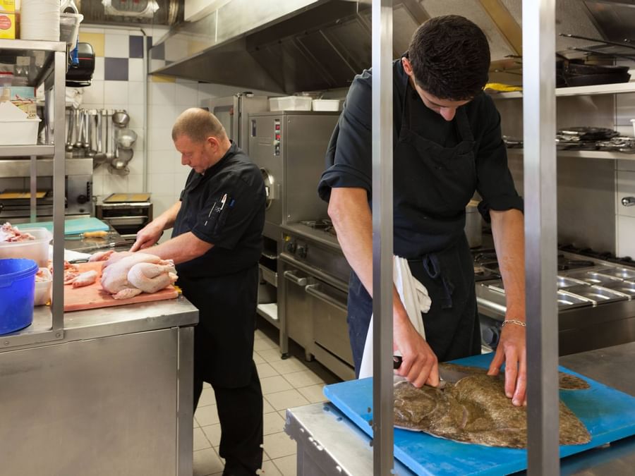 A chefs preparing meals in a restaurant at Le Germinal