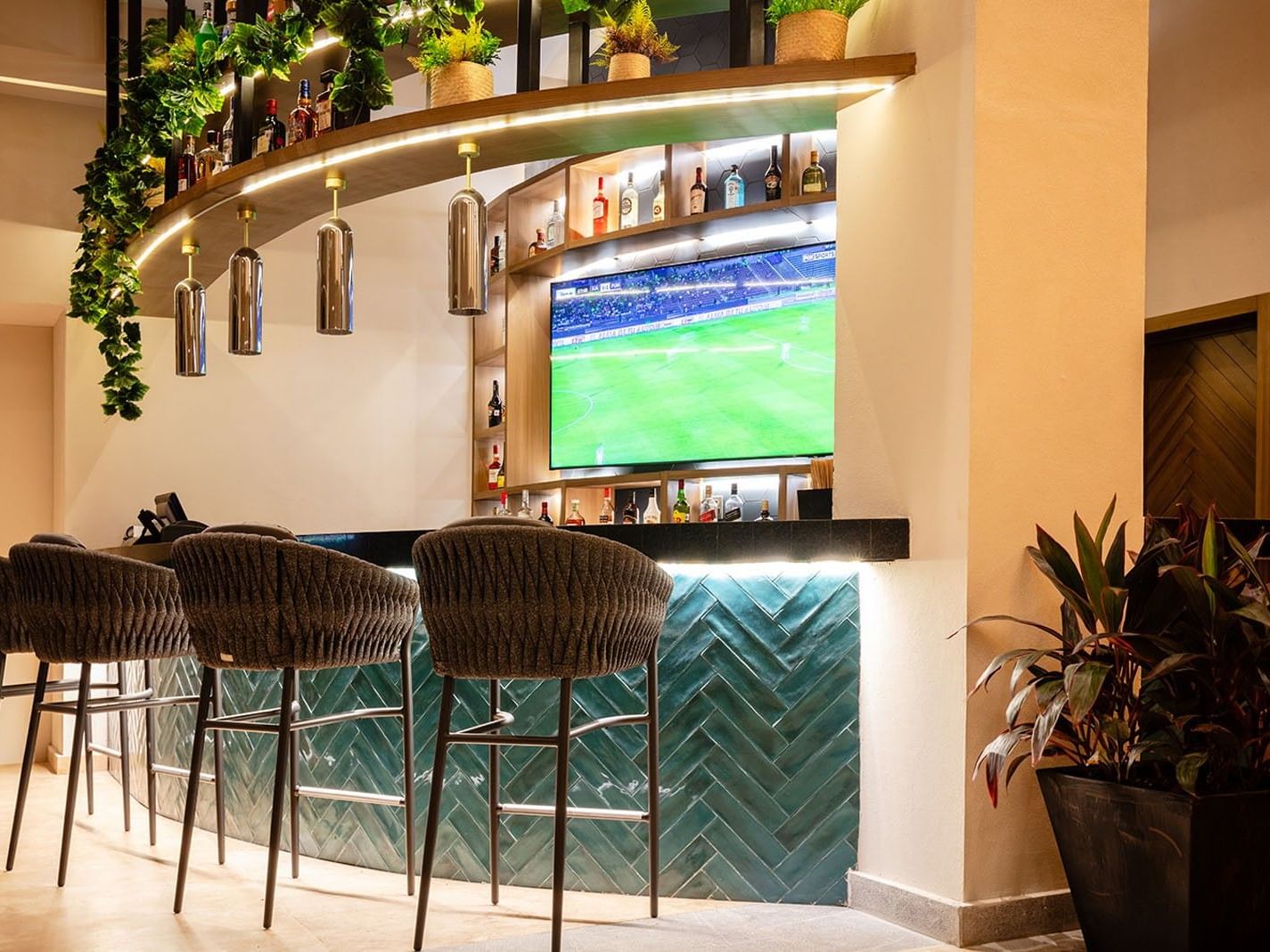 Blue Bar setup with four woven stools facing a teal herringbone-patterned counter at Camino Real Acapulco Diamante