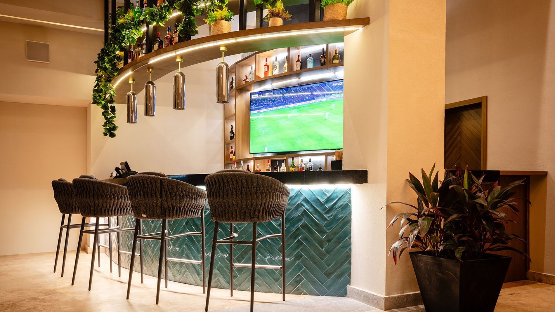 Blue Bar setup with four woven stools facing a teal herringbone-patterned counter at Camino Real Acapulco Diamante