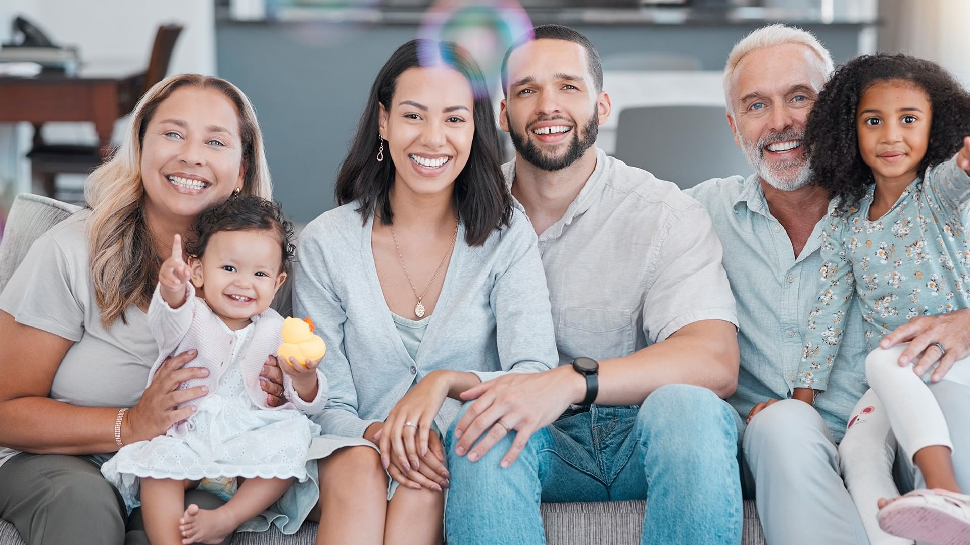 Happy family portrait on a sofa, with a father, mother, and three kids near the Coast Lonsdale Quay Hotel