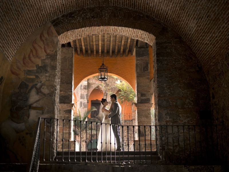 Wedded couple posing by a stairway at FA Hacienda San Antonio