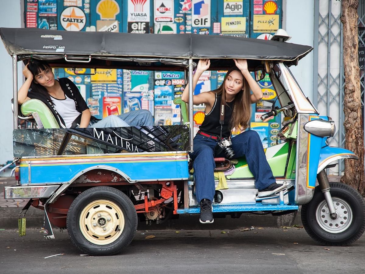 2 girls posing on a three-wheeler near Maitria Hotels