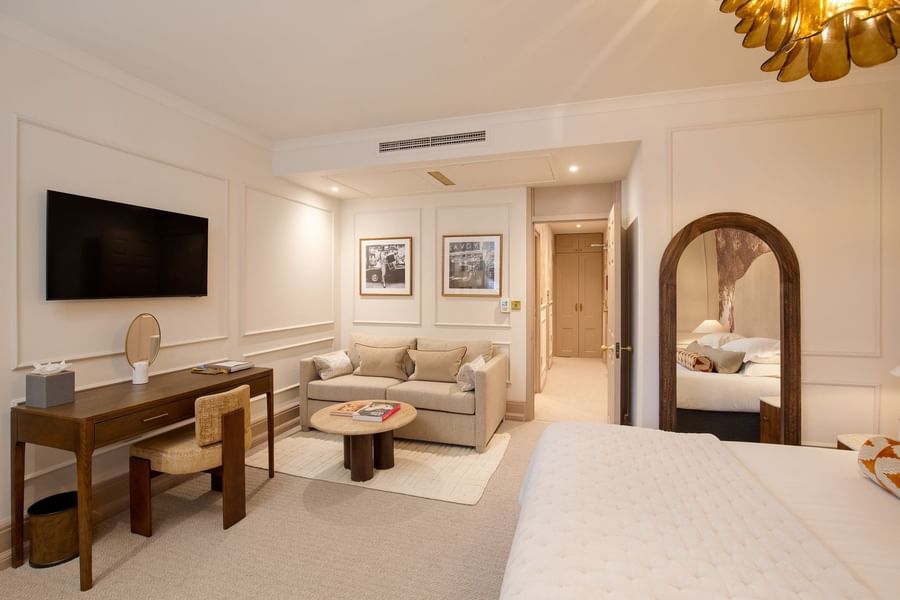 TV with work desk facing bed and sofa in Studio Apartment at The Capital Hotel, Apartments and Townhouse