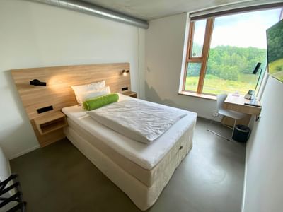 Work desk and bed by the window in Premium Single Room Queen Bed at Avaneo Hotel, featured in hotel room photos