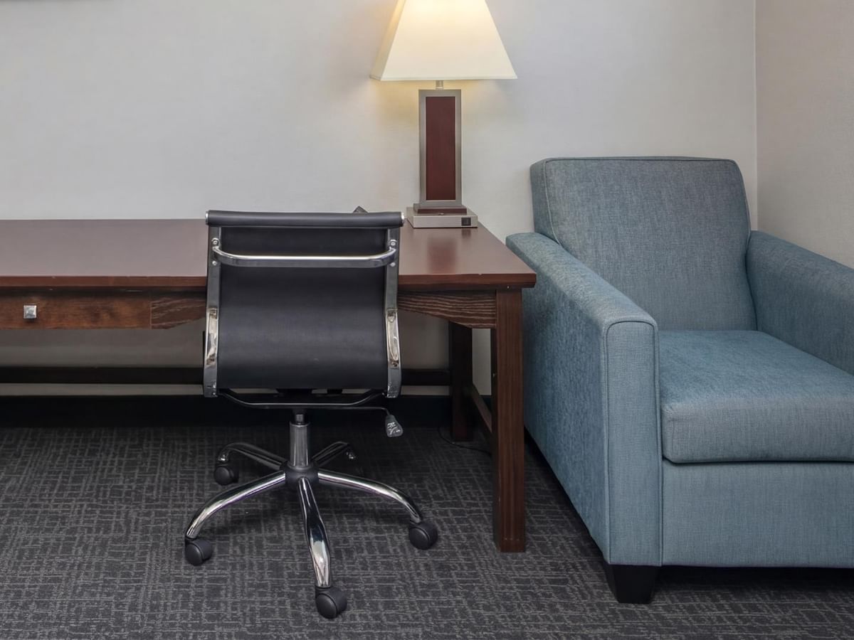 Desk and armchair with a lamp.