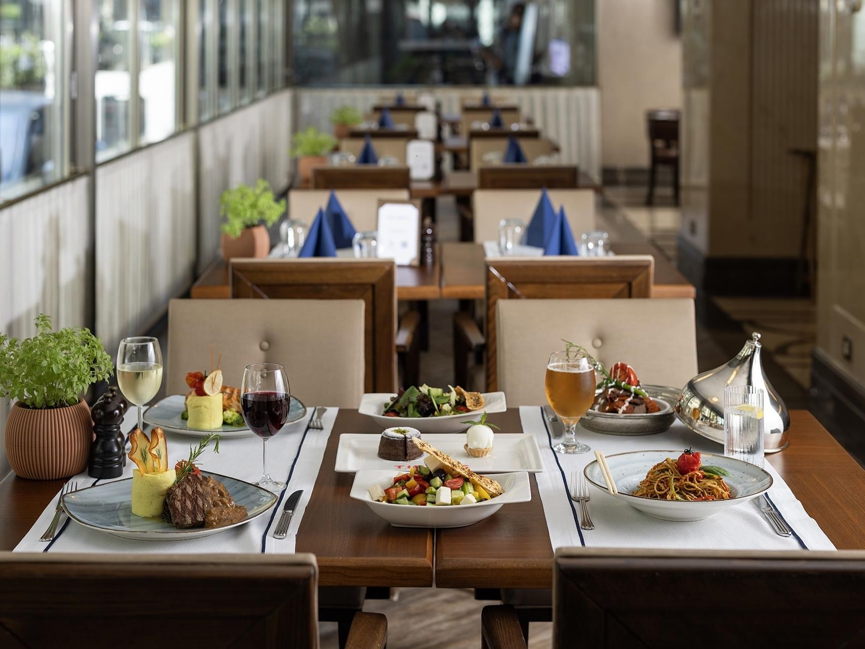 Pascarella Restaurant with neatly set tables, each adorned with various dishes, glasses, and utensils, under natural light in Titanic City Taksim.