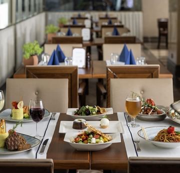 Pascarella Restaurant with neatly set tables, each adorned with various dishes, glasses, and utensils, under natural light in Titanic City Taksim.