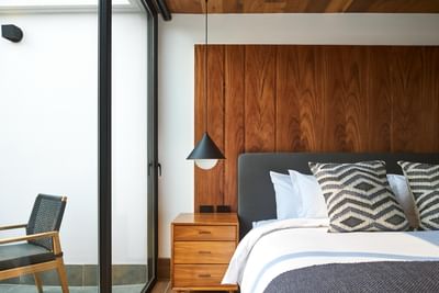 Bedroom with a large bed, wooden furniture, and a balcony in Casa Cielo at Singular Signature Residences