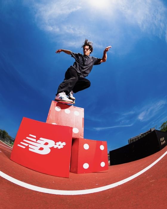 Person performing skateboard trick on red dice-shaped obstacles against blue sky at Showboat Hotel & Resort Atlantic City