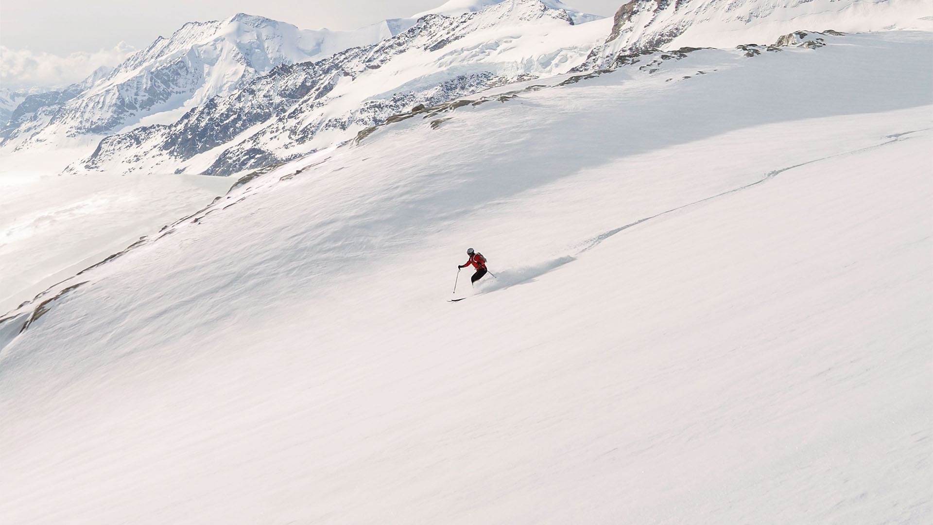 A man skiing down a snowy mountain near Falkensteiner Hotels